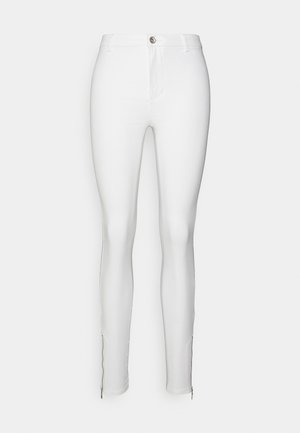 Hvite skinny jeans laget av elastisk stoff, med frontglidelås, frontlommer og glidelåser i kanten for justerbar passform.