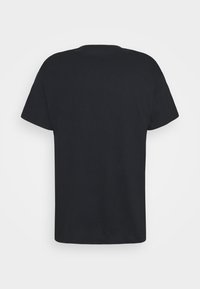 Camiseta negra de manga corta hecha de algodón con un corte relajado. Diseño simple, sin patrones ni gráficos, con cuello redondo.