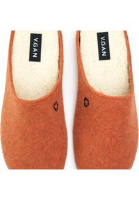 Orange wool slip-on shoes with a soft cream lining and subtle black recycling logo detail. Simple, rounded design.