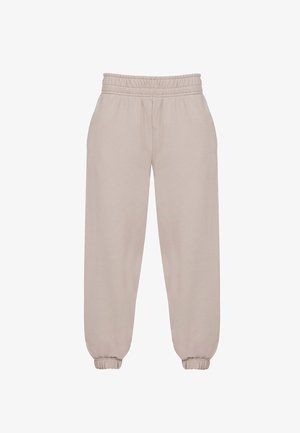 Beżowe spodnie dresowe wykonane z miękkiego materiału, z elastycznym paskiem w talii, zakończone ściągaczami na kostkach i luźnym krojem dla wygody.