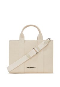 Sac tote en toile de couleur blanc cassé, doté de deux poignées arrondies et d'une bandoulière amovible. Logo du designer imprimé sur le devant. Fini texturé.