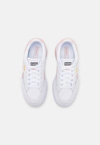 Białe sneakersy z różowymi akcentami, płaskimi sznurowadłami, wyściółką na kołnierzu oraz logo na języku, z teksturowaną gumową podeszwą i gładką skórzaną cholewką.