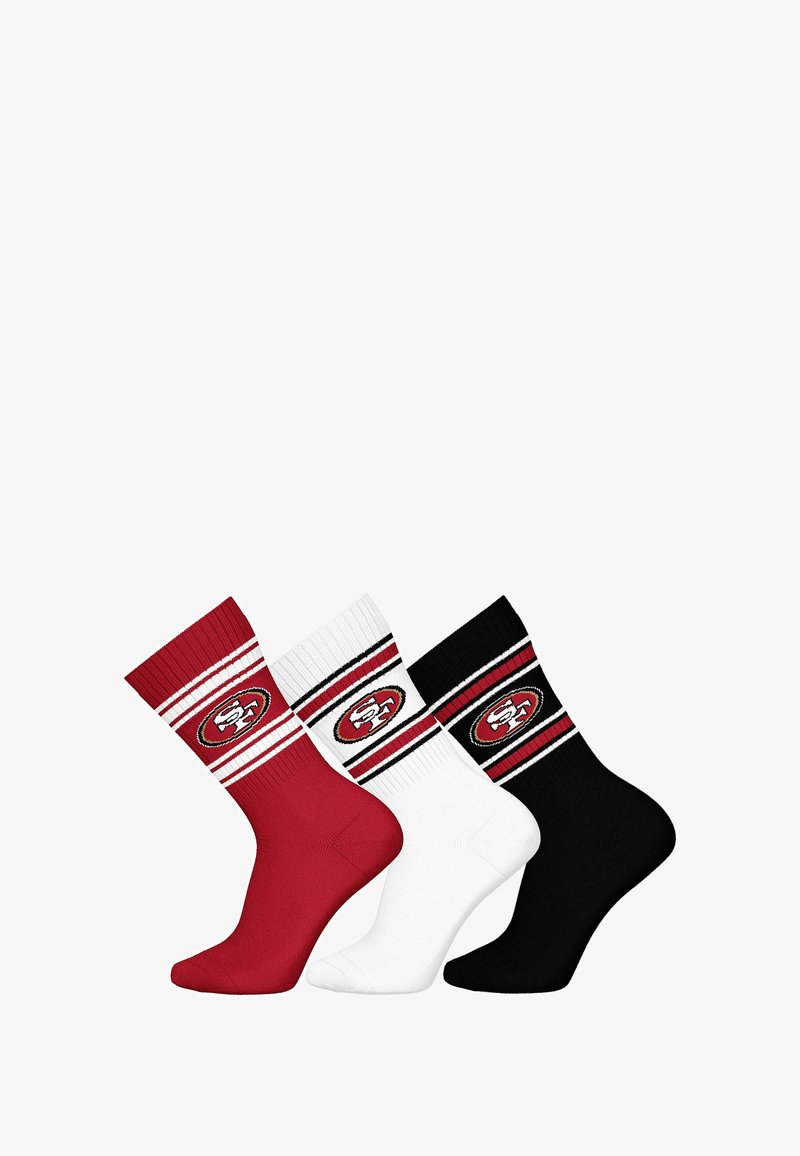 Tres pares de calcetines de tripulación: rojo, blanco y negro. Cada uno tiene un puño acanalado grueso y presenta un logo circular con los colores y franjas del equipo.