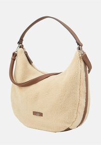 Beżowa torebka z futra syntetycznego o zaokrąglonym kształcie, z brązowymi skórzanymi akcentami, pojedynczym paskiem na ramię i srebrnym detalem.