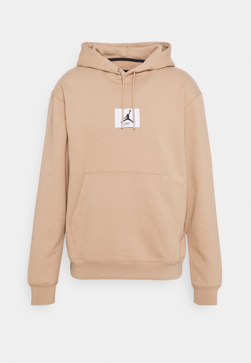 Sweat-shirt à capuche beige avec poche kangourou à l'avant, cordon de serrage à la capuche et petit patch logo blanc représentant une silhouette noire d'un joueur de basket-ball.
