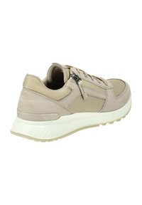 Beige athletic shoe featuring a mix of suede and mesh material, rounded toe, textured accents, and a thick white sole. Side zip detail visible.