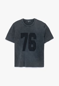 Czarny t-shirt z krótkim rękawem, okrągłym dekoltem i dużym czarnym nadrukiem "76" z przodu. Miękka, lekko wyblakła tekstura.