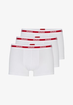 Valged puuvillased bokserid kolmes komplektis, millel on punane elastne vöökoht "HUGO" brändingu ja lühikeste jalgade disain.