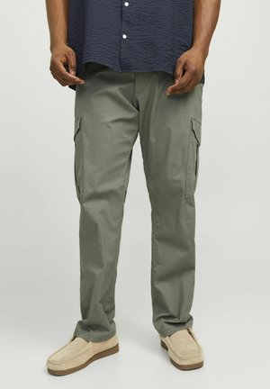 Cargo bukser i olivengrøn, med sidelommer, lige snit og letvægtsstof. Kombineret med beige slip-on sko.