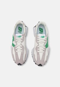 Baskets avec un mélange de blanc, de suède gris et un accent vert. Présente un design texturé, une fermeture à lacets et une semelle extérieure en caoutchouc noir.