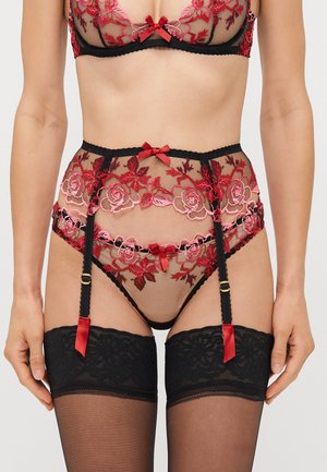 Black lace lingerie set featuring sheer mesh with red embroidery. Includes garter belt with bows and matching thigh-high stockings.