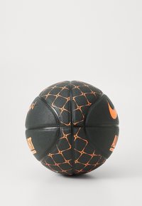 Sort basketball med orange accenter, der har en tekstureret overflade og et geometrisk mønster. Brandlogoet vises tydeligt.