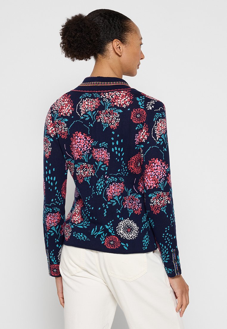 Maglione a maglia floreale in blu navy con fiori rosa, rossi e turchesi, colletto a coste e maniche lunghe con dettagli a bottoni ai polsini.
