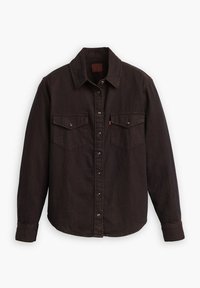 Chemise en denim noir à manches longues, avec un devant à boutons, deux poches poitrine et un col pointu. Présente des accessoires en métal argenté et une texture subtile.