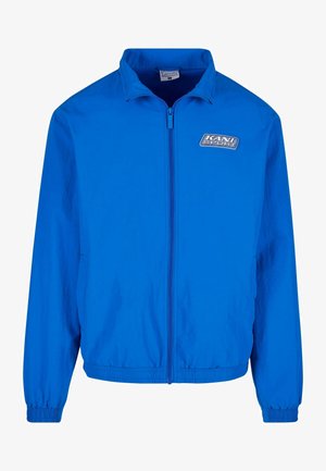 Blaue Windbreaker-Jacke mit einem langen Frontreißverschluss, elastischen Bündchen und einem elastischen Saum. Mit dem 'KANI SPORT'-Logo auf dem oberen linken Brustbereich.