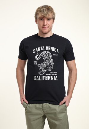 Black cotton t-shirt featuring a white tiger graphic and text reading "Santa Monica Tiger Bay" and "California" in bold font.