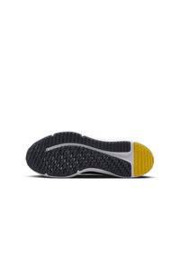 Shoe outsole featuring a black rubber base with a textured pattern, white midsole, and a yellow accent at the heel.
