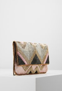 Bolso de mano con cuentas que presenta un patrón geométrico de zigzag en gris, negro, rosa y dorado, con cierre de broche y detalle metálico.
