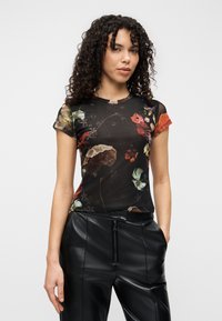 Μαύρο τοπ με λουλουδάτο μοτίβο από ελαφρύ ύφασμα με υφή. Διαθέτει κοντά μανίκια με πολύχρωμες λεπτομέρειες. Συνδυάζεται με μαύρο δερμάτινο παντελόνι.