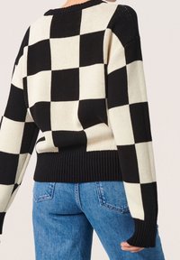 Schwarzer und cremefarbener kariert Pullover mit geripptem Saum und Bündchen, entspannter Passform und weitem Ärmeln, gestrickter Textur und markantem Muster.