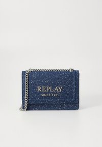 Kabelka z námorníckej modrej textúrovanej látky so strieborným reťazovým remienkom, s klopovým zapínaním a vyrazeným logom „REPLAY SINCE 1981“ na prednej strane.
