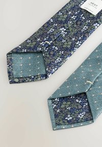 Cravat cu model floral în nuanțe de albastru marin și verde. Prezintă flori vibrante și o față interioară texturată de culoare verde mentă cu accente punctate.