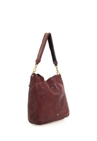 Borsa in pelle di un rosso profondo con una forma morbida. Presenta una superficie testurizzata, dettagli in oro e una tracolla in tessuto a fantasia.