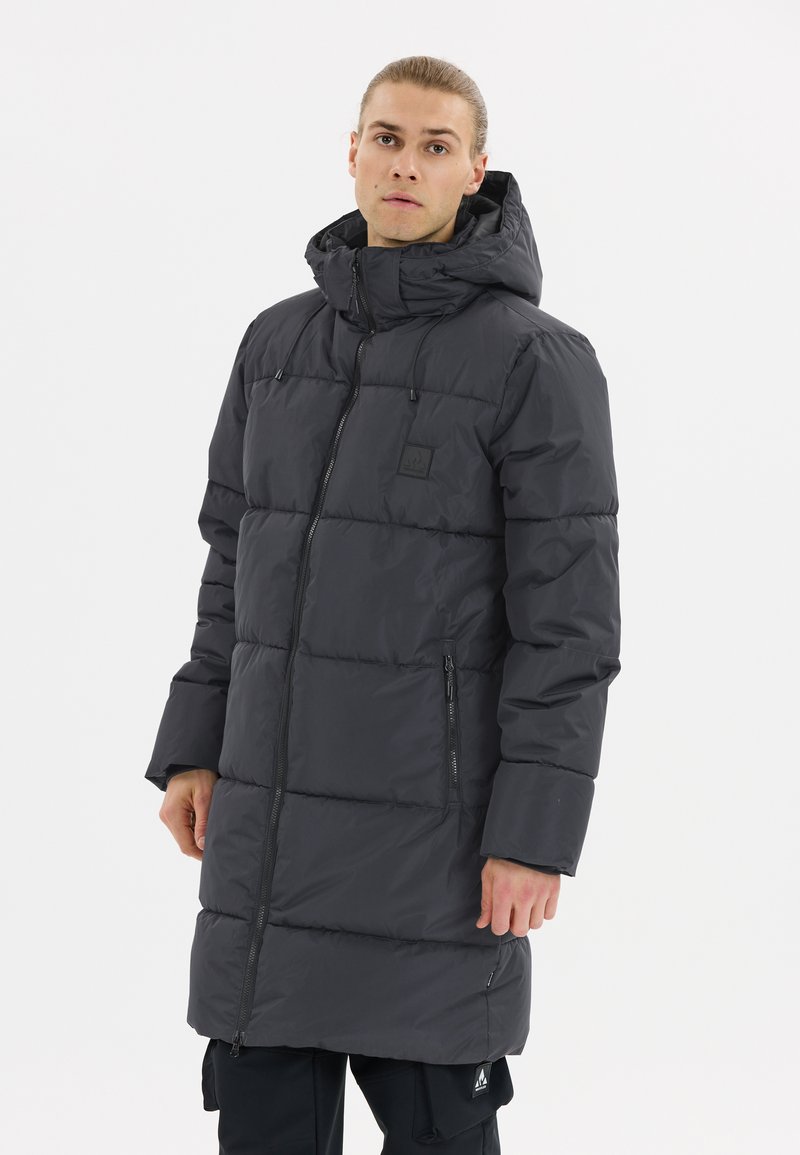 Parka noire rembourrée avec un col haut, capuche réglable, fermeture éclair frontale et poches latérales ; présente une texture matelassée et une patch logo sur la poitrine.
