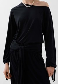 Černý dlouhý rukáv top s odhalenými rameny, s draped designem a uzlem v pase, vyroben z měkkého, elastického materiálu.