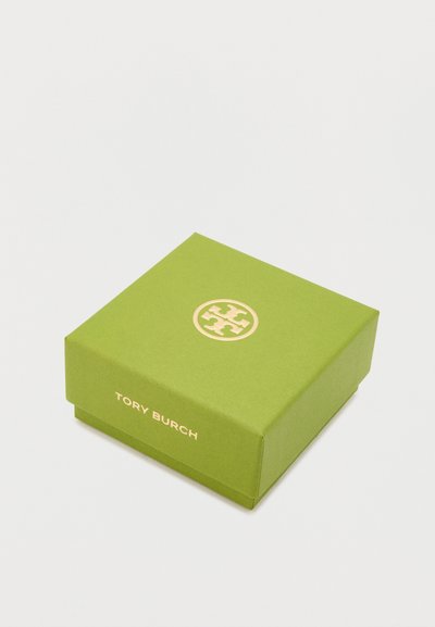 Zelena kartonska kutija s zlatim logom na vrhu, koja ima glatku teksturu i minimalistički dizajn, označena imenom "Tory Burch."