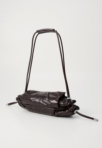 Dark brown leather shoulder bag with adjustable strap and drawstring closure on a plain light background.