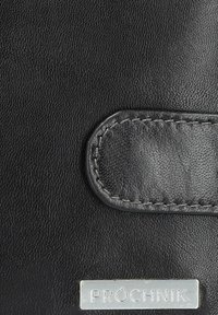 Czarny skórzany portfel z teksturowaną powierzchnią, zaokrąglonymi brzegami, naszywką ze skóry oraz srebrną tabliczką z logo.