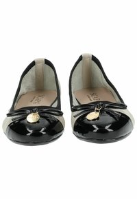Black and cream patent leather ballet flats with a rounded toe, bow detail, and gold logo charm on the front. Soft inner lining.