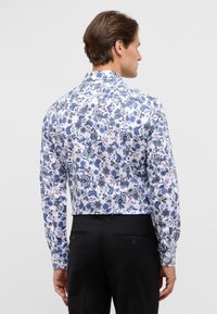 Langarmshirt met een witte basis en blauwe bloem- en paisleypatronen. Met kraag, slim-fit ontwerp en een gladde stoftextuur.