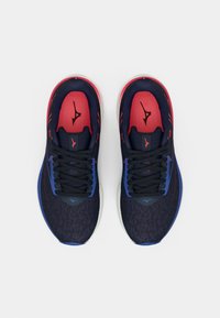 Marineblå og røde joggesko med teksturert overdel, svarte snøringer og hvit såle. Har logo-ikoner i kontrasterende farger.