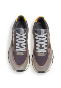 Scarpe sportive grigie e marroni realizzate in materiali misti come mesh e suede, con una forma robusta, accenti testurizzati e dettagli riflettenti sui lacci.