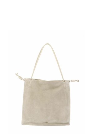 Sac fourre-tout en daim beige avec une fine sangle d'épaule et des détails noués sur les côtés, coutures minimalistes, et un petit logo doré près du bas au centre.