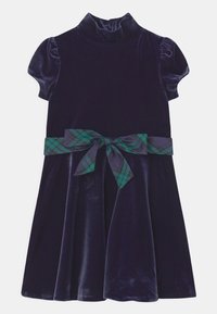 Námořnicky modré sametové šaty s krátkými nafouklými rukávy, vysokým límcem a rozšířenou sukní. V pase je ozdobný pásek ze zelené a námořnicky modré kárované stuhy.