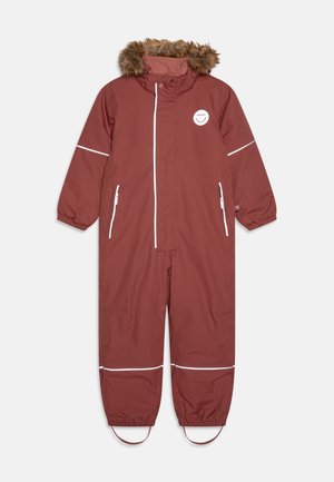 Rød vanntett overalldress med hette fôret med kunstpels, hvite detaljer, to sidelommer og elastiske mansjetter ved håndleddene og anklene.