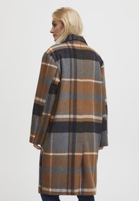 Wool coat featuring a brown, gray, and blue plaid pattern; a straight cut with a collar and side pockets. Soft texture and long sleeves.