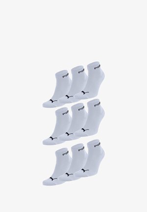 Weiße Knöchelsocken aus einem Baumwollmischgewebe, mit einem schwarzen PUMA-Logo und -Bande, in gestapelter Anordnung präsentiert.