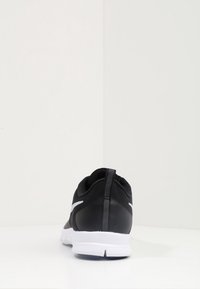 Scarpa sportiva nera con tomaia in rete, dettagli bianchi e pannelli testurizzati. Presenta una suola ammortizzata e un laccio sul tallone.
