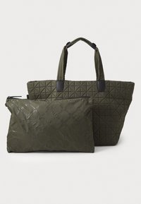 Fôret olivengrønn tote bag med svarte detaljer og geometriske mønstre, sammen med en mindre glidelås-pose i matchende materiale.