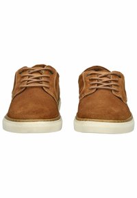 Braune Stoff-Schnürschuhe mit strukturierten Oberflächen, weißen Gummisohlen und gestickten Akzenten, von vorne betrachtet.