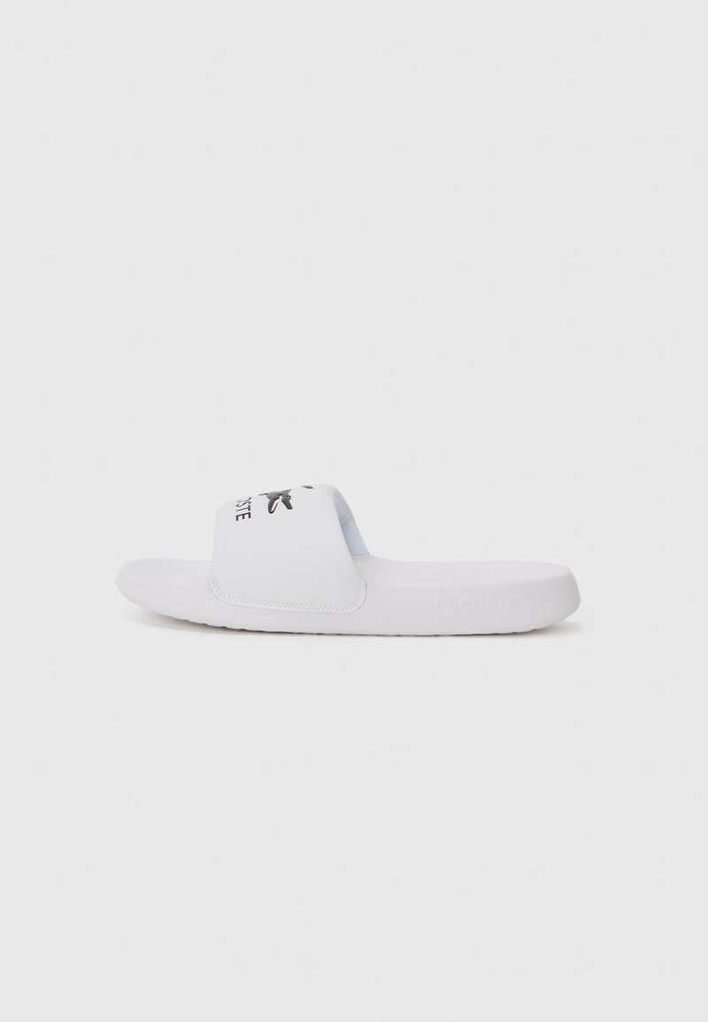 Sandale blanche à glissière avec une large sangle arborant un logo noir, une semelle texturée et un design minimaliste. Fabriquée en matériau synthétique doux.