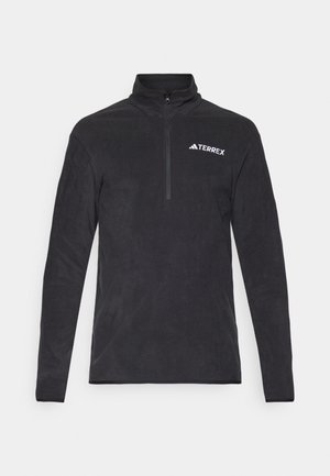 Pull en polaire noir avec col montant, fermeture à zip quart, et logo TERREX sur la poitrine gauche. Texture douce et manches longues.