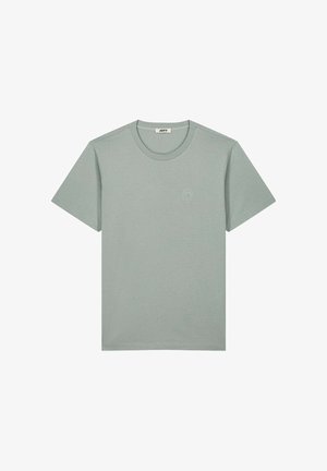 Maglietta a maniche corte verde chiaro, girocollo, con un logo ricamato sottile sul lato sinistro del petto e un'etichetta del marchio all'interno del colletto.