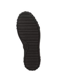 Semelle en caoutchouc noir avec texture striée et bords festonnés, dotée d'un logo circulaire et d'un design distinct de la semelle intérieure pour une adhérence optimale.