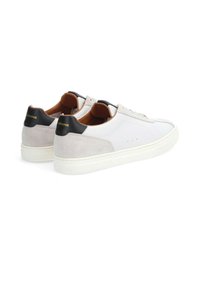 Weiße und graue Sneakers mit einer Wildleder-Oberfläche, schwarzen Akzenten an der Ferse und einer glatten Oberfläche. Verfügt über ein klassisches Design und eine Gummisohle.