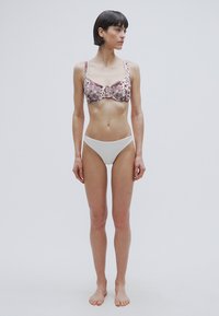 Σουτιέν με φλοράλ σχέδιο σε αποχρώσεις μπορντό και εκρού; σετ με απλό λευκό μαγιό σλιπ χαμηλής μέσης; το ύφασμα φαίνεται λείο και ελαφρύ.